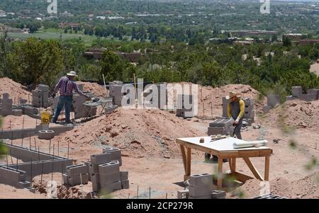 I lavoratori edili lavorano alla fondazione di un blocco di legno di una nuova casa in costruzione a Santa Fe, New Mexico USA. Foto Stock