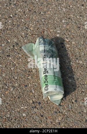 Una copia del New York Times consegnata a casa all'interno di una borsa di plastica riciclabile si trova in un vialetto a New Mexico, USA. Foto Stock