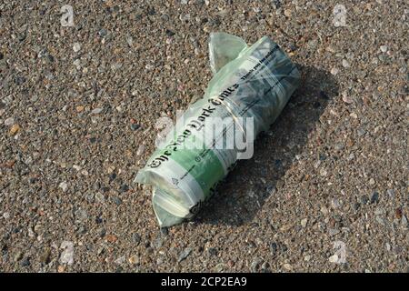 Una copia del New York Times consegnata a casa all'interno di una borsa di plastica riciclabile si trova in un vialetto a New Mexico, USA. Foto Stock