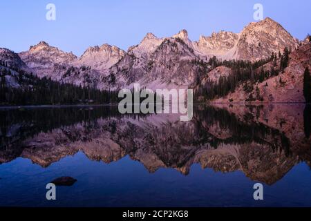 Alice Lake riflette le vette circostanti al crepuscolo, Sawtooth Wilderness, Idaho, Stati Uniti. Foto Stock