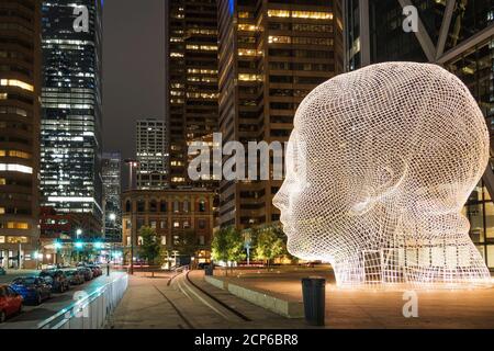 Vista notturna della famosa scultura del paese delle meraviglie del famoso artista e scultore spagnolo Jaume Plensa nel centro di Calgary, Alberta, Canada. Foto Stock