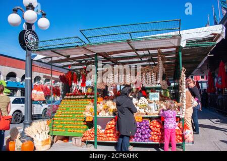 Zucche dipinte con colori e prodotti agricoli in una cabina di vendita In Byward Market con la gente che acquista sotto il cielo soleggiato di autunno Foto Stock