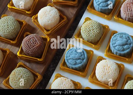 Mooncakes di pelle di neve nel mezzo del processo di imballaggio. Collocato su un contenitore in plastica dorata; pronto per il tappo e sigillato Foto Stock