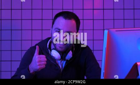 Gioioso giocatore che gioca video giochi sul computer e mostra gio Foto Stock