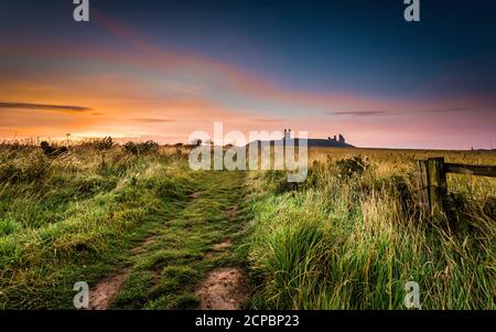 Alba al castello di Dunstanburgh in Northumberland. Foto Stock