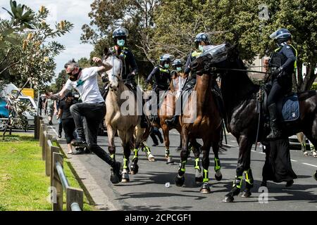 Melbourne, Australia. 19 settembre 2020. Un protetore salta una recinzione per fuggire da agenti di polizia Victoria montati in una strada sulla spiaggia a Elwood durante una protesta anti-maschera e anti-blocco che era iniziata a Elsternwick Park, Melbourne Australia. Credit: Michael Currie/Alamy Live News Foto Stock