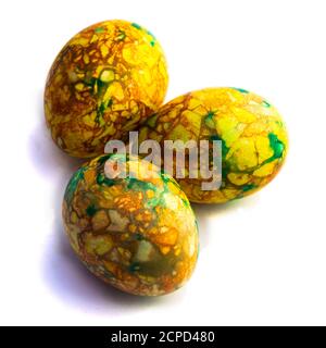 Tradizioni. Uova di pasqua di colore giallo verde fatte a mano dipinte in marmo su sfondo bianco Foto Stock