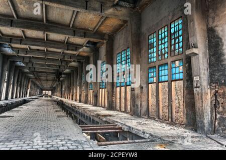 antico edificio industriale abbandonato con finestre blu, rovine industriali, fabbrica dismessa Foto Stock