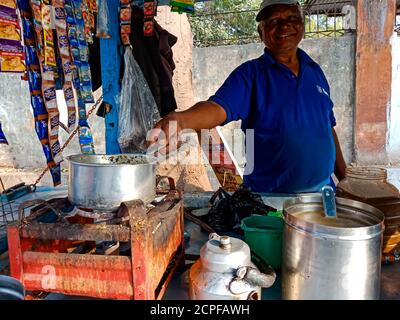 DISTRETTO KATNI, INDIA - 18 GENNAIO 2020: Un uomo indiano che fa il tè dalla stufa che brucia sull'angolo del cibo di strada. Foto Stock