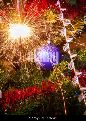 Decorazione di Natale su un albero di Natale con un sacco di scintille da sparkler Foto Stock