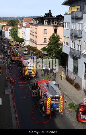 Dresda, Germania. 19 Settembre 2020. I veicoli di emergenza della vigile del fuoco si trovano di fronte a un edificio di appartamenti dopo un incendio. Si dice che il fuoco sia iniziato in un appartamento al secondo piano e poi si è allargato alla capriata del tetto attraverso il controsoffitto. Un uomo saltò fuori dalla finestra della casa il sabato mattina per salvarsi dal fuoco. Gli è stato immediatamente dato cure mediche di emergenza e portato in un ospedale. Non ci sono state altre lesioni. Credit: Sebastian Kahnert/dpa-Zentralbild/dpa/Alamy Live News Foto Stock