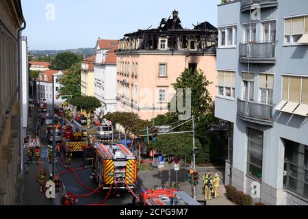 Dresda, Germania. 19 Settembre 2020. I veicoli di emergenza della vigile del fuoco si trovano di fronte a un edificio di appartamenti dopo un incendio. Si dice che il fuoco sia iniziato in un appartamento al secondo piano e poi si è allargato alla capriata del tetto attraverso il controsoffitto. Un uomo saltò fuori dalla finestra della casa il sabato mattina per salvarsi dal fuoco. Gli è stato immediatamente dato cure mediche di emergenza e portato in un ospedale. Non ci sono state altre lesioni. Credit: Sebastian Kahnert/dpa-Zentralbild/dpa/Alamy Live News Foto Stock