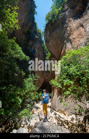 Escursionisti nel canyon con alberi verdi, ripide scogliere della Garganta Verde, Sierra de Cádiz, provincia di Cádiz, Spagna, Europa Foto Stock