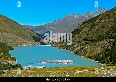 Lago di montagna Lac des Toules con pannelli solari della prima centrale solare galleggiante alpino in Svizzera, Bourg-St-Pierre, Vallese, Svizzera, UE Foto Stock