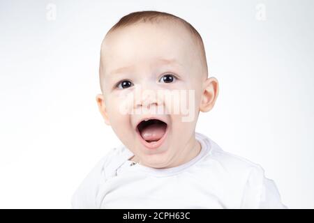 Foto di un bambino di undici mesi sorpreso su sfondo bianco Foto Stock