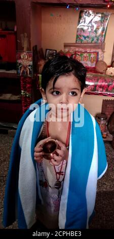 DISTRICT KATNI, INDIA - 02 GENNAIO 2020: Un piccolo ragazzo indiano carino andare per adorare dio indù a casa. Foto Stock