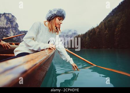 Bella donna che visita un lago alpino a Braies, Italia - turista con outfit escursionistico divertirsi in vacanza durante il fogliame autunnale - concetti su tr Foto Stock