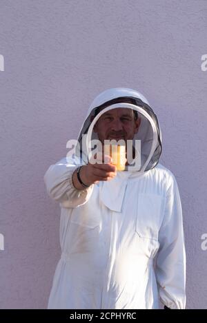 L'apicoltore tiene in mano un vaso di miele Foto Stock