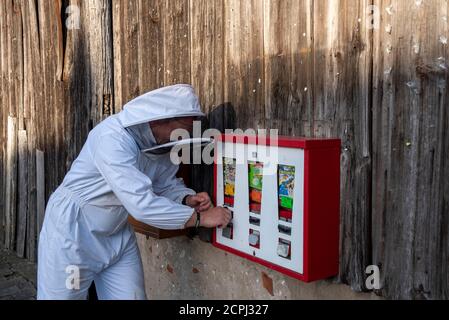 L'apicoltore è a una macchina per la gomma Foto Stock