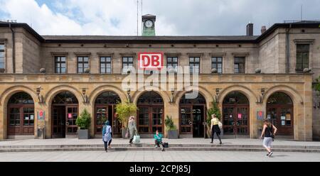 Germania, Baviera, Erlangen, stazione centrale, piazzale, logo DB, facciata della casa, passanti, viaggiatori Foto Stock