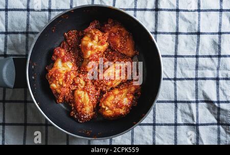 Pollo fritto piccante, stile coreano, in padella Foto Stock