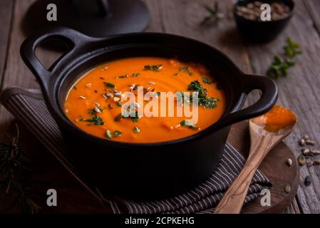 Zuppa di zucca calda in pentola su fondo scuro Foto Stock