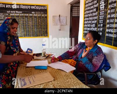 DISTRETTO KATNI, INDIA - 21 GENNAIO 2020: Il principale della scuola del governo indiano che parla con i genitori del villaggio al tavolo dell'ufficio. Foto Stock