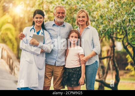 Felice famiglia sana e dottore di parlare nel parco. Persone sanitario e medico personale concetto di servizio. Foto Stock