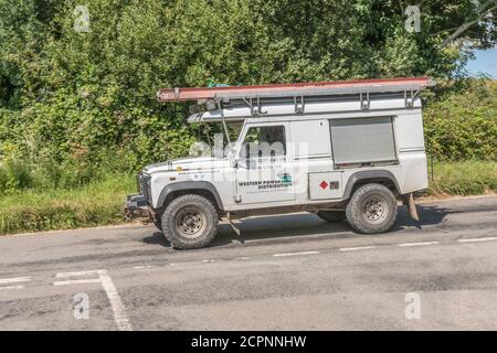 White Land Rover utilizzato come veicolo di servizio per la distribuzione dell'energia elettrica occidentale su una strada rurale in Cornovaglia. WPD è il principale fornitore di elettricità della Cornovaglia Foto Stock