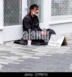 Londra, Regno Unito, 19 settembre 2020, l'uomo senza tetto seduto sul marciapiede che supplica per soldi da solo evidenziando la crisi immobiliare del Regno Unito Foto Stock