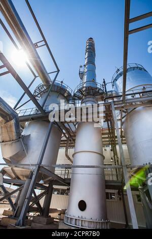 Regione di Kzylorda/Kazakistan - aprile 30 2012: Impianto di acido solforico. Forni per bruciare zolfo e fumare stack (camino di fabbrica). Cielo blu con sole b Foto Stock