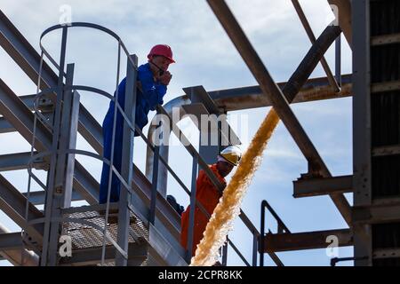 Impianto acido solforico. Lavare e pulire le attrezzature con acqua. Due lavoratori sovrintendenti. Foto Stock