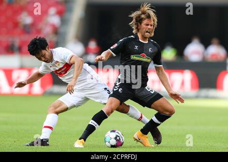 Stoccarda, Germania. 19 Settembre 2020. Calcio: Bundesliga, VfB Stuttgart - SC Friburgo, 1° incontro, Mercedes-Benz Arena. Wataru Endo (l) di Stoccarda e Lucas Höler di Friburgo combattono per la palla. Credito: Tom Weller/dpa - NOTA IMPORTANTE: In conformità con le norme del DFL Deutsche Fußball Liga e del DFB Deutscher Fußball-Bund, è vietato sfruttare o sfruttare nello stadio e/o nel gioco le fotografie scattate sotto forma di sequenze di immagini e/o serie di foto di tipo video./dpa/Alamy Live News Foto Stock