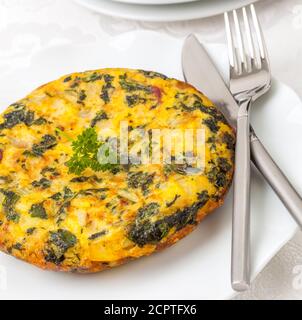 Spessa frittata alla spagnola con patate e spinaci Foto Stock