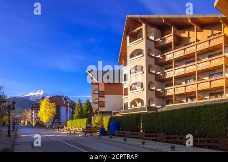 Bansko, Bulgaria - 23 novembre 2019: Vista autunnale di via Pirin con case, alberi colorati e montagne Pirin Foto Stock