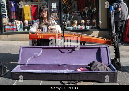 Glasgow, Scozia, Regno Unito. 19 settembre 2020. Regno Unito Meteo. Un artista di strada che si esibisce su un guzheng (Zither cinese) in via Buchanan. Credito: SKULLY/Alamy Live News Foto Stock