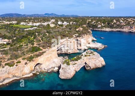 Costa ripida con la porta di roccia es Pontas nel mare, Cala Santayi, vicino a Santanyí, regione del Migjorn, immagine del drone, Maiorca, Isole Baleari, Spagna Foto Stock