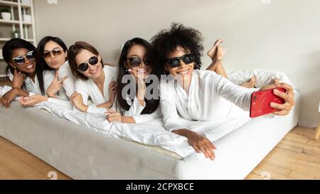 Felici amici multirazziali in abiti che posano per selfie. Foto Stock