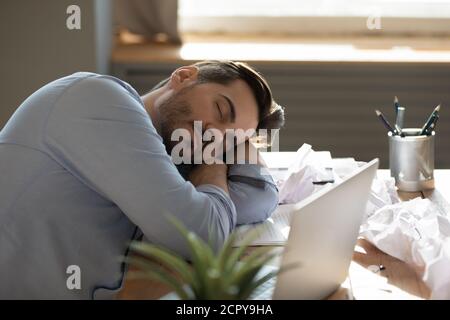 I dipendenti maschi esausti si addormentano sul posto di lavoro Foto Stock