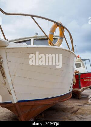 Barche da pesca rosse e bianche ormeggiate a secco sul molo, porto di Latchi, Cipro Foto Stock