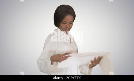 Sorridente donna afroamericana medico che legge cardiogramma su gra Foto Stock