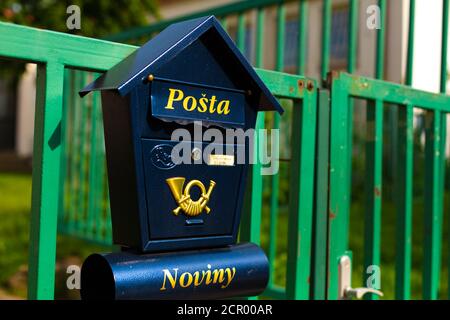 Casella postale blu elegante sullo sfondo di una recinzione verde nella Repubblica Ceca. Foto Stock