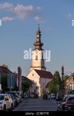 Vista dalla piazza principale alla chiesa parrocchiale (S. Jakobuskirche) alla luce della sera, Leibnitz, Stiria, Austria Foto Stock