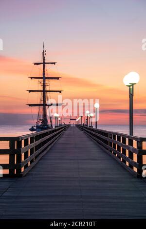 Germania, Meclemburgo-Pomerania occidentale, isola di Ruegen, Ostseebad Binz, una nave a vela ha ormeggiato al molo, alba, alba Foto Stock