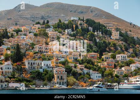 SYMI, GRECIA - AGOSTO 2019: Vista panoramica sul paesaggio urbano della città di Symi Foto Stock