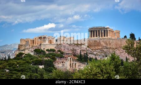 Vista della collina dell'Acropoli e del teatro di Odeon ad Atene, Grecia dalla collina di Philopapos o Muses in estate luce del giorno con grandi nuvole nel cielo blu. Foto Stock