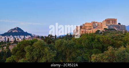 Vista della collina dell'Acropoli e della collina di Lycabettus sullo sfondo di Atene, Grecia dalla collina di Pnyx in un cielo di tramonto estivo. Foto Stock