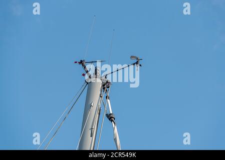 Anemometro, bussola, antenne, luce di posizione sull'albero di una barca a vela Foto Stock