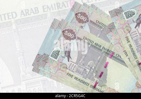 500 le banconote da dirham degli Emirati Arabi Uniti sono impilate sullo sfondo di una grande banconota semitrasparente. Presentazione astratta della moneta nazionale. Concetto aziendale Foto Stock