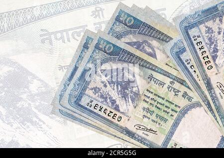 50 le rupie nepalesi si trovano in pila sullo sfondo di una grande banconota semitrasparente. Presentazione astratta della moneta nazionale. Concetto aziendale Foto Stock